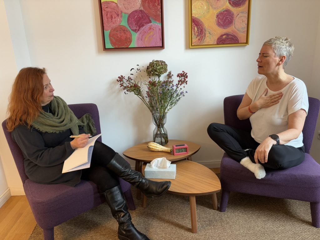 Anne Voß, Coachin für The Work of Byron Katie, sitzt ruhig und macht Notizen – achtsam, präsent und empathisch