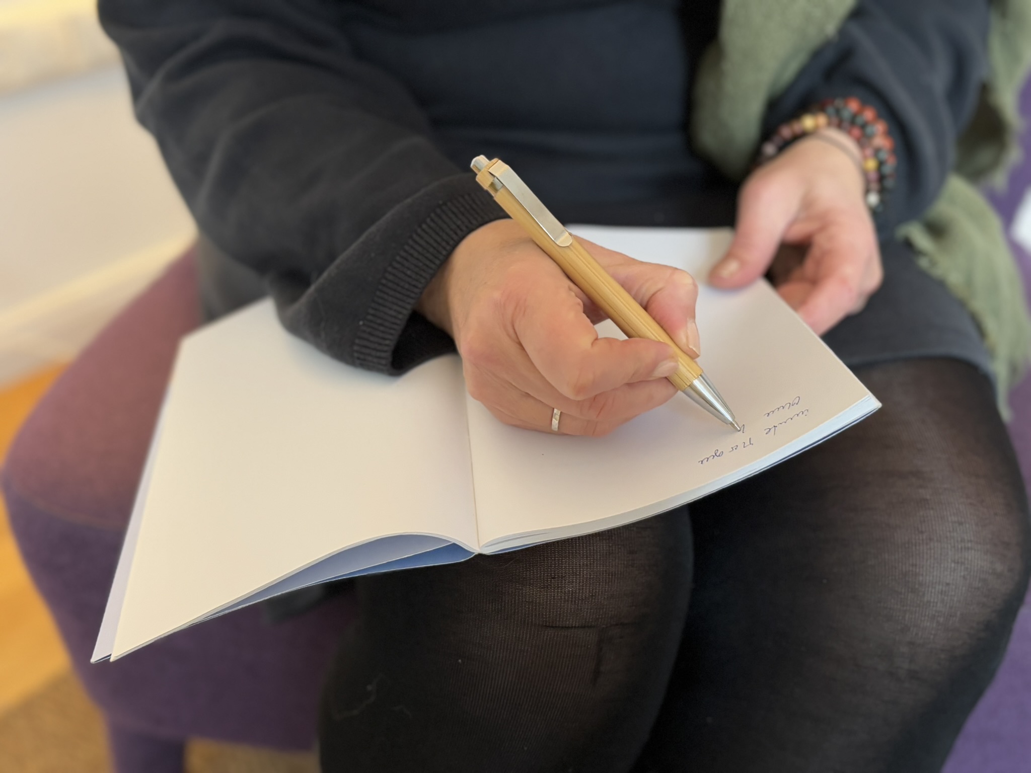 Hand schreibt achtsam in ein Notizbuch – Symbol für Selbstreflexion, Klarheit und den Coachingprozess mit The Work of Byron Katie.